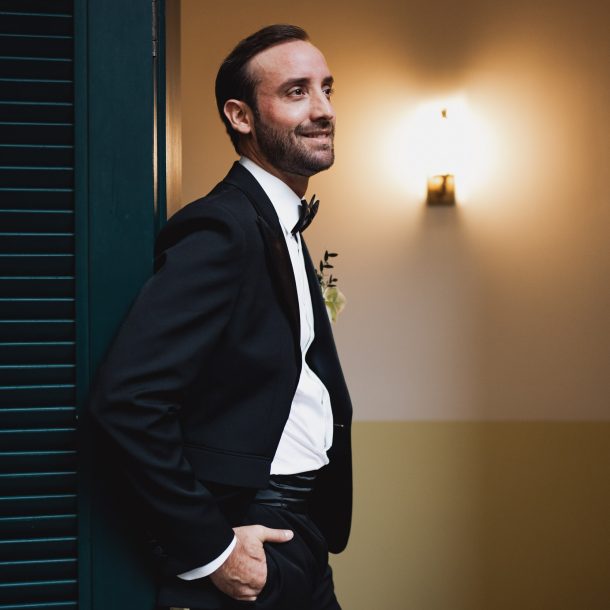 Novio posando contra una puerta