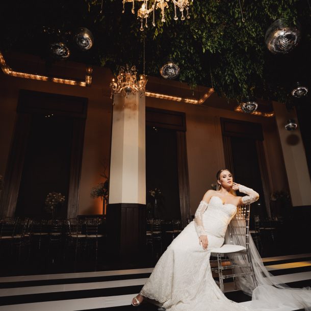 Novia posando en una silla en su salón de recepción