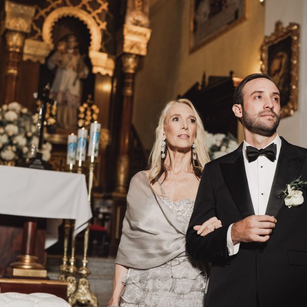 Novio mirando la entrada de la novia en la iglesia con su mamá